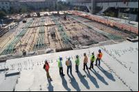 trabalhadores da construção civil no topo de uma estrutura 