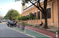 homem sentado em banco em frente a ciclovia