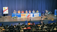 pessoas em mesa diante de plateia