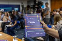 mão segurando livreto do plano de segurança viária de campinas