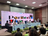 pessoas em mesa de solenidade com telão projetando o logo do Periferia Viva