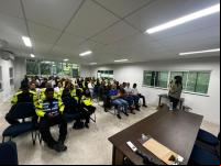 mulher fala em frente a pessoas em sala de aula
