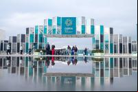 pessoa caminha no pórtico de entrada da COP29 em Baku