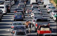 vendedores ambulantes em meio a carros em congestionamento