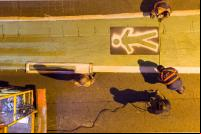 imagem de homens pintando faixa de pedestres no chão de rua