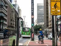 homem em bicicleta em ciclovia de são paulo aguarda semáforo em cruzamento da rua augusta