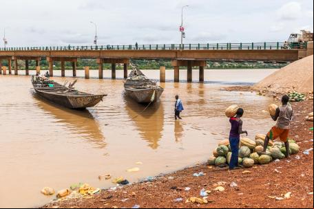 Homens preparam carregamento de melancias à beira de rio no Níger