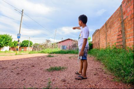 Menino em bairro precário de Teresina aponta para ponto de ônibus