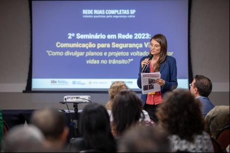 mulher fala sobre segurança viária diante de telâo