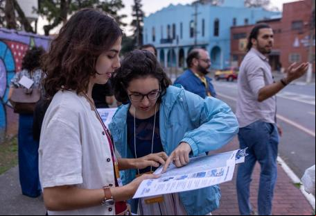mulheres observam planta de intervenção viária