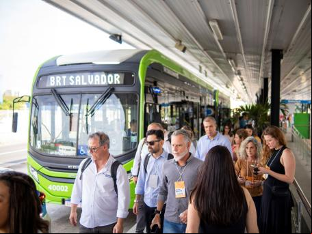 pessoas caminham em frente a ônibus elétrico