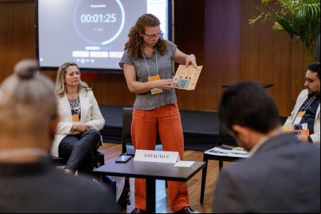mulher apresenta projeto para pessoas sentadas