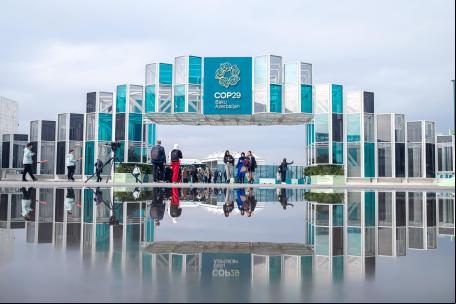 pessoa caminha no pórtico de entrada da COP29 em Baku