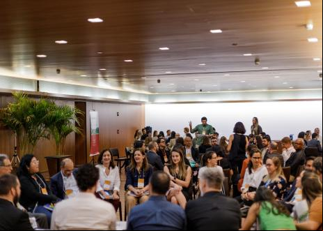 reunião com muitas pessoas sentadas conversando sobre projetos