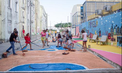 Adultos e crianças pintam rua em residencial em região vulnerável