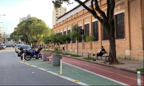 homem sentado em banco em frente a ciclovia