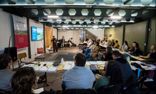 pessoas reunidas assistindo a apresentação de um projeto
