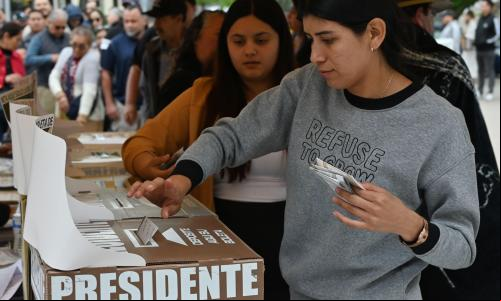 mulher deposita voto na urna no México
