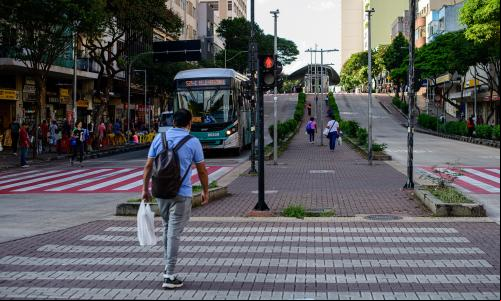 homem caminha em pavimento vermelho e texturizado