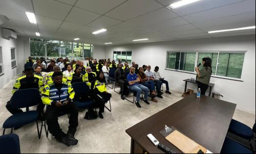 mulher fala em frente a pessoas em sala de aula