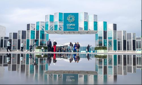pessoa caminha no pórtico de entrada da COP29 em Baku