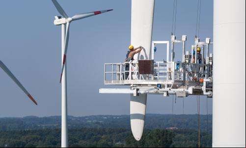 homem faz manutenção em turbina eólica