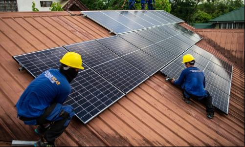 Trabalhadores de uma empresa alemã-filipina de energia solar instalam painéis em uma casa em Quezon City, nas Filipinas
