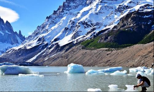 imagem de homem examinando lago congelado próximo a cordilheira dos andes
