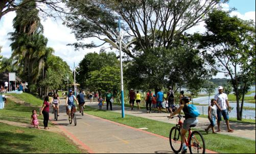 parque com ciclovia e pessoas caminhando e pedalando