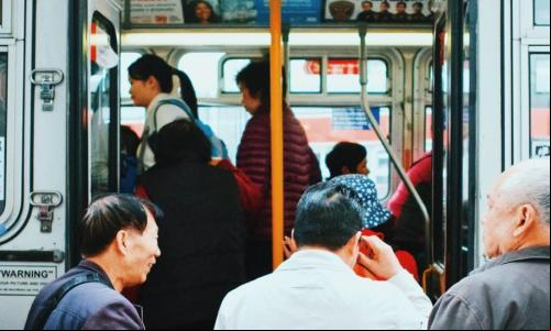 pessoas esperando para embarcar em um ônibus coletivo